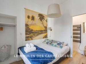 a bedroom with a bed with a painting on the wall at Les Carmélites - Appartements dans l'hyper-centre de Rennes in Rennes