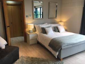 a bedroom with a large bed and a mirror at Penrith Retreats in Penrith