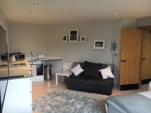 a living room with a couch and a kitchen at Penrith Retreats in Penrith