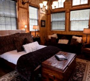 a bedroom with a bed and a couch and a table at Lovely Weekend Getaway Rental near Edgar Evins State Park in Tennessee in Gordonsville