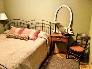a bedroom with a bed and a mirror and a chair at Comfortable Room Rental for a Vacation in Poweshiek County, Iowa in Montezuma