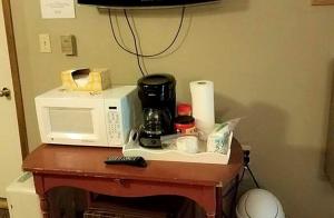 a microwave sitting on top of a table at Comfortable Room Rental for a Vacation in Poweshiek County, Iowa in Montezuma
