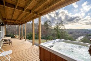 a hot tub on a wooden deck with a view at Fantastic Glamping Tiny Home Rental on The Toccoa River in Blue Ridge, Georgia in Mineral Bluff