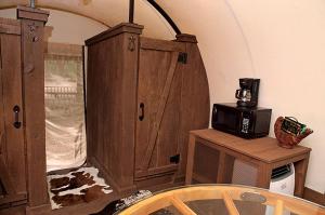 a kitchen with a microwave on top of a cabinet at Unique Wagon Accommodation at Bed and Breakfast near Austin, Texas in Cat Spring