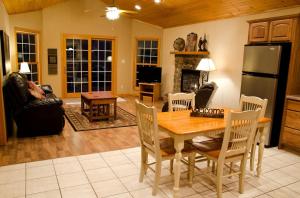 a living room with a table and a refrigerator at Wonderful Lakefront Cabin with Hot-tub in Carbondale, Illinois in Etherton +17 photos