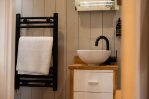a bathroom with a white sink and a towel at Driftwood with Hot Tub in Corpach +21 photos