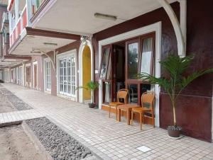a corridor of a building with chairs and windows at Lippo Pantai Carita 9270 in Anyer