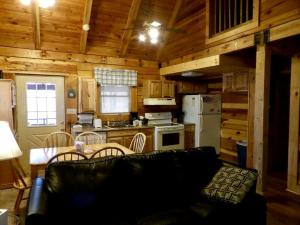 a living room with a couch and a kitchen at Spacious Cabin Rental with a Hot Tub near the Gauley River in West Virginia in Hico +1 photo