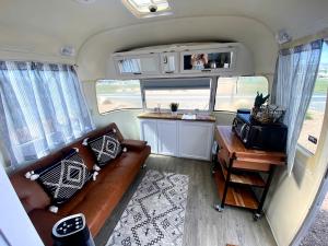 ein Wohnzimmer mit Sofa und Tisch in einem Wohnmobil in der Unterkunft Pet-Friendly Airstream Adventure in Colorado, Perfect Glamping Escapes in Grand Junction in Grand Junction