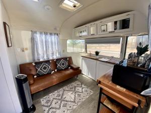 - soggiorno in camper con divano in pelle di Pet-Friendly Airstream Adventure in Colorado, Perfect Glamping Escapes in Grand Junction a Grand Junction