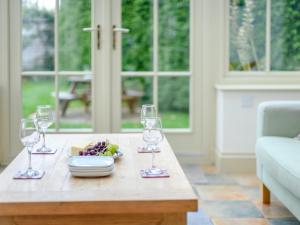 a table with wine glasses and a plate of fruit at 5 Bed in Godshill NFL35 in Godshill +19 photos
