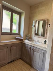 un bagno con lavandino e specchio di La-Villanelle - Magnifique vue sur le lac, 5 minutes à pied de la plage a Veyrier-du-Lac