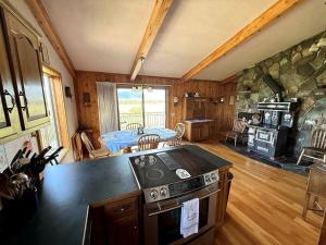 a kitchen with a stove top oven in a room at Charming Riverfront Guest House with Deck Overlooking Madison River, Near Ennis, Montana in Ennis