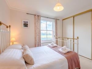 een slaapkamer met een groot bed met twee handdoeken bij 5 Bed in Godshill NFL35 in Godshill +19 foto's