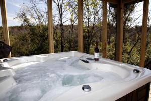 bañera con botella de vino en Impressive Secluded Cabin with Hot-tub in Herod, Illinois, en Karbers Ridge