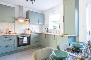 a kitchen with blue cabinets and a table with chairs at Beverley 2 bedroom Central Home Garden Parking in Beverley