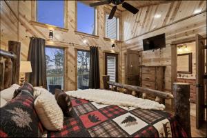 a bedroom with a large bed in a wooden cabin at Beautiful Log Cabin with Private Hot Tub, Fire Pit, and Spacious Balcony, Perfect for a Luxury Mountain Retreat in Mount Herman