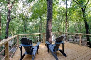 a deck with two chairs and a tree in the woods at Lofted Romantic Tree House Immersed in Nature in Alabama in Grant +29 photos