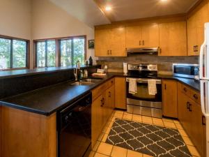 a kitchen with wooden cabinets and a black counter top at Tree-House Style Cabin for Rent near Boone, North Carolina in Beech Mountain