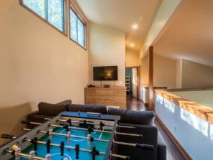 a living room with a ping pong table at Tree-House Style Cabin for Rent near Boone, North Carolina in Beech Mountain