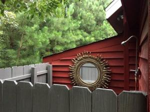 Un espejo en la pared lateral de una casa roja con una cerca. en Serene Tiny House with a Big Charm for Glamping in Virginia, en Accomac 34 fotos más