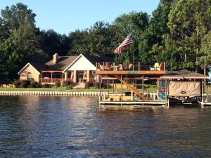una casa su un molo sull'acqua di Spacious Cottage Rental on the Shores of Cedar Creek Lake in Mabank, Texas a Enchanted Oaks