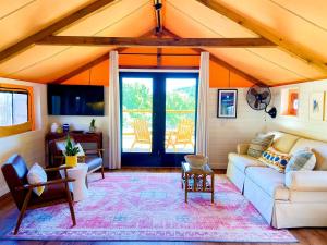 a living room with a couch and a table at Beautiful Tented Cabin in Texas for Glamping by Guadalupe River in Hunt