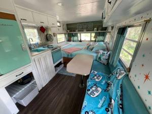 an interior of an rv with a bedroom and a kitchen at Marble Falls Retro Caravan Glamping: Your Vintage Getaway Awaits in Marble Falls