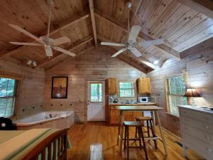 a kitchen with wooden walls and a ceiling with two fans at Tranquil Riverside Cabin Haven Near New River, Virginia in Galax +3 photos