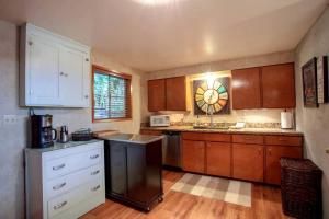a kitchen with wooden cabinets and a counter top at Dog Friendly Cabin on Lake Pend O'reille with Hot Tub and Lakefront Views, Perfect for a Family Retreat on the Lake in Broten
