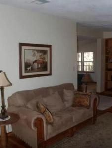 a living room with a brown couch in a room at Secluded Cabin near Ocala National Forest in Central Florida in Fort McCoy