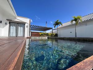 a swimming pool in front of a house at The Royal Vista by SOV in Grand-Baie