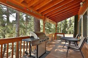 un porche cubierto con parrilla y mesa de picnic en Peaceful Cabin Surrounded by Nature for a Memorable Getaway in Duck Creek Village, Utah, en Duck Creek Village