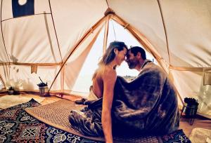 a man and a woman sitting in a tent at The Pink Pony Yurt, New Cuyama, CA in New Cuyama