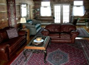 ein Wohnzimmer mit Ledersofas und einem Couchtisch in der Unterkunft Gorgeous Private Cottage Rental in the Black Hills of South Dakota in Nemo
