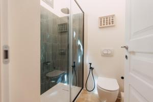 a bathroom with a glass shower and a toilet at Dimora Crocefisso in Noto +16 photos