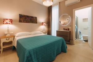 a bedroom with a bed and a bathroom with a mirror at Dimora Crocefisso in Noto