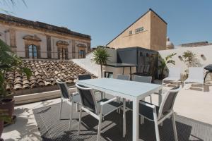 a table and chairs on the roof of a building at Dimora Crocefisso in Noto