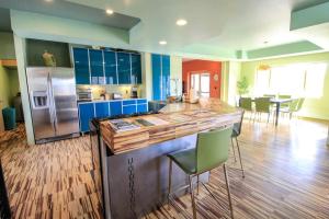 a kitchen with blue cabinets and a counter with chairs at Colorful Cabin with Hot-Tub, Game Room and Gym in Montana in Coram +46 photos