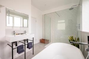 Un baño blanco con lavabo y ducha en Luxury Tenby Old Town Retreat just 1-minute to Beach with Parking, en Pembrokeshire 45 fotos más