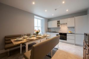 Una cocina y un comedor con mesa y sillas. en Luxury Tenby Old Town Retreat just 1-minute to Beach with Parking, en Pembrokeshire