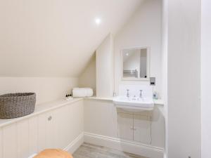 a white bathroom with a sink and a mirror at 2 Bed in Tisbury 78165 in Tisbury +13 photos