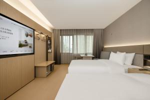 Ένα ή περισσότερα κρεβάτια σε δωμάτιο στο JI Hotel Guangzhou Taojin Subway Station