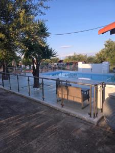 a table and benches in front of a pool at John & Jenny's Small Village in Agios Andreas