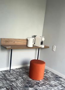 a shelf on a wall with cups and a stool at Unit Hotel in Almaty
