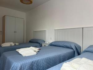 a bedroom with two blue beds with towels on them at Casa Sol y Valle in Sotillo de la Adrada
