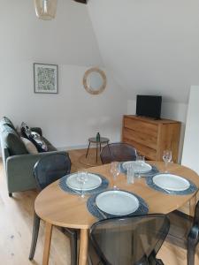 a table with plates and glasses on it in a living room at T3 CENTRE VILLE 2ème étage in Angers