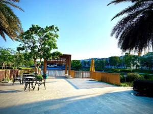 a patio with a table and chairs and a umbrella at Modern 3BR Villa , Poolside, 4min Shuttle to Beach in Bình Tú