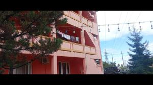 a red building with clothes hanging on a clothes line at Отель in Gonio