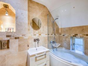 a bathroom with a tub and a sink at 2 Bed in Nr Beadnell 77990 in Ellingham +15 photos